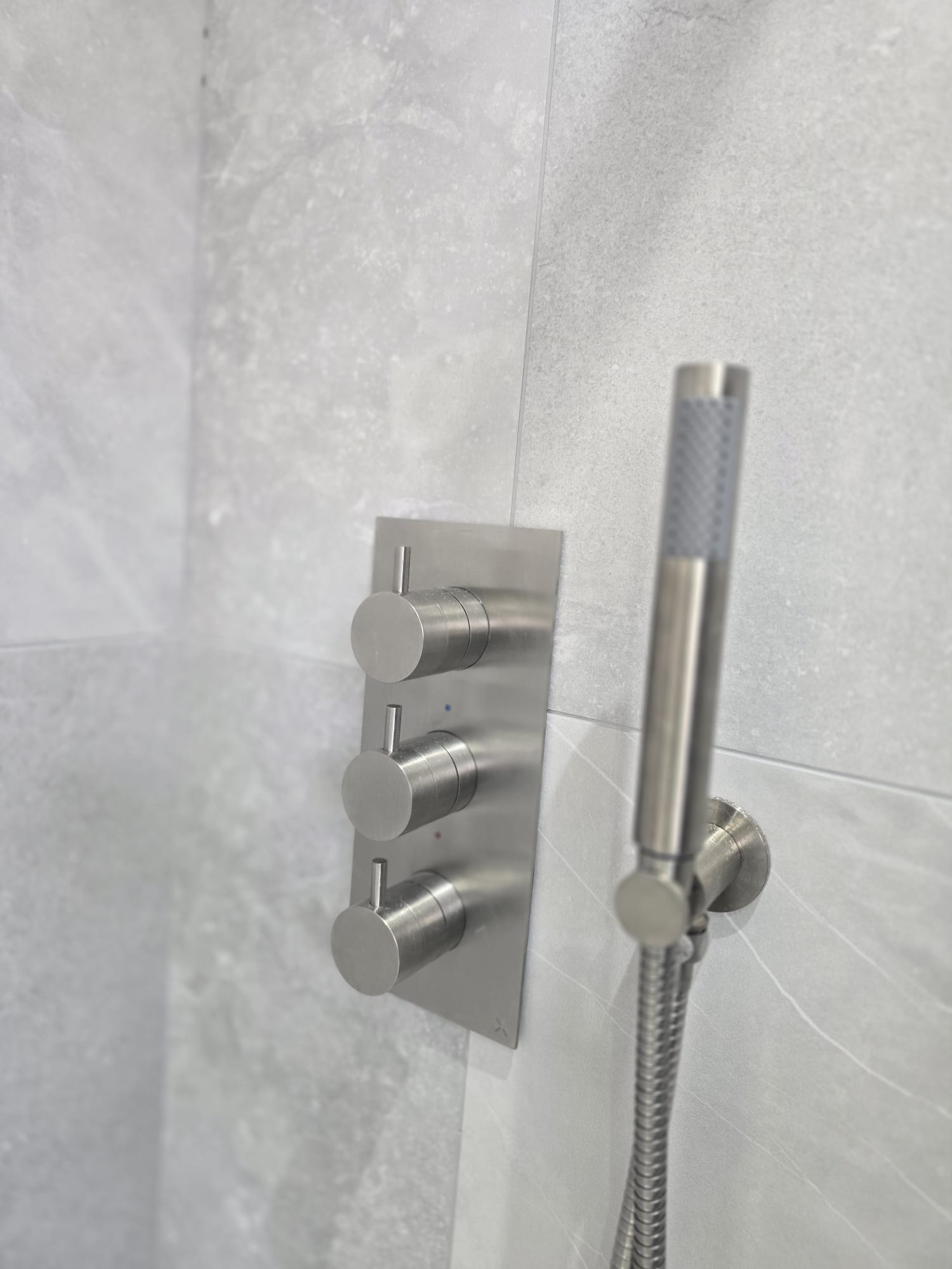 https://fixandflipconstruction.co.uk/wp-content/uploads/2026/08/brushed-steel-shower-valve-handset-detail.jpg