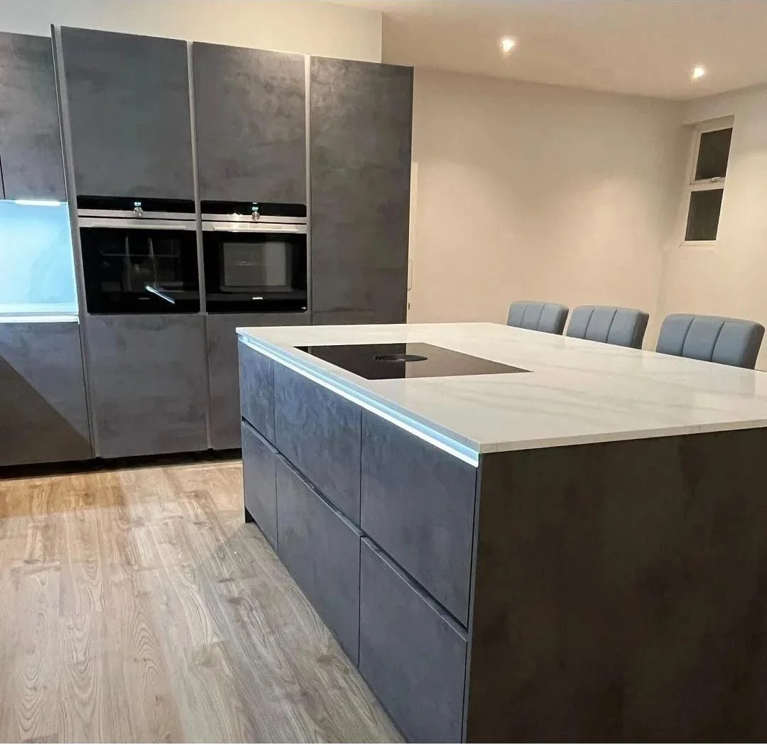 https://fixandflipconstruction.co.uk/wp-content/uploads/2026/08/grey-stone-effect-kitchen-double-ovens-island.webp